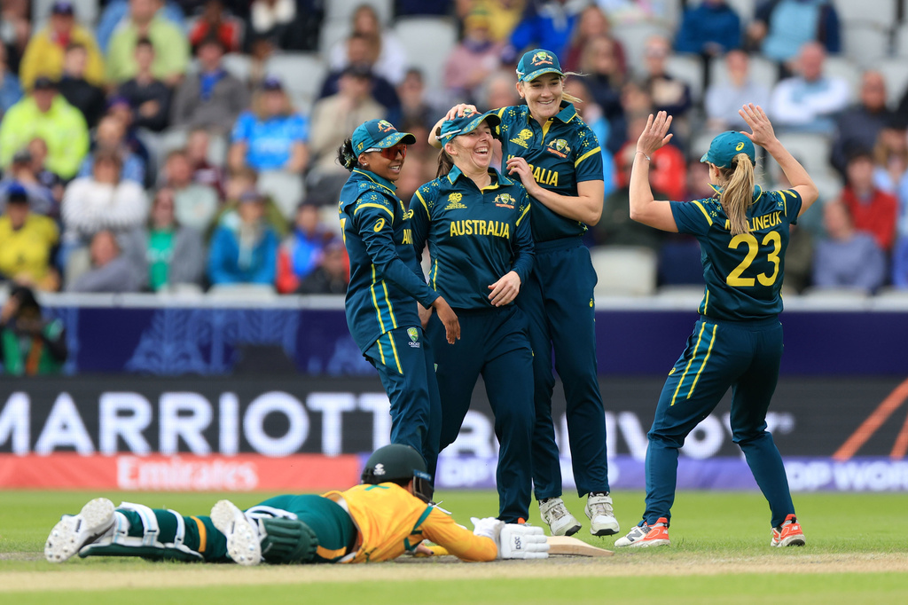 Australia's Georgia Wareham, center, celebrates with teammates after running out South Africa's Marizanne Kapp, on the ground, during the Women's T20 World Cup match between Australia and South Africa at Old Trafford, Manchester, England, Saturday June 13, 2026. (Nigel French/PA via AP)