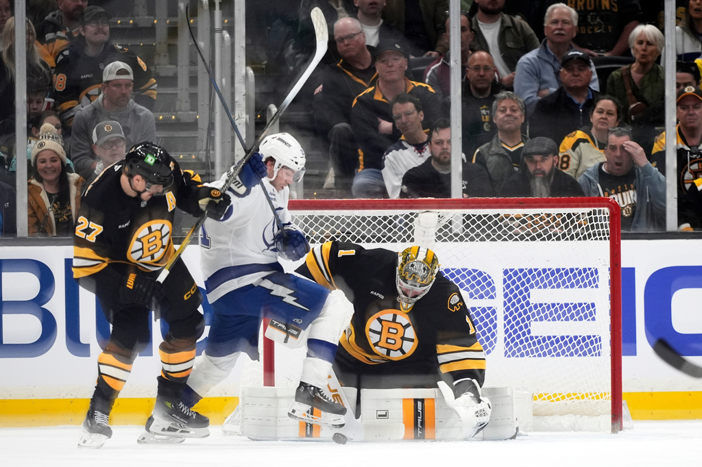 Tampa Bay Lightning center Brayden Point, center, battles for a loose puck with Boston Bruins defenseman Hampus Lindholm (27) in front of Bruins goaltender Jeremy Swayman during an NHL hockey game, Saturday, April 11, 2026, in Boston. (AP Photo/Robert F. Bukaty)
