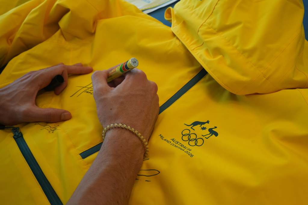 Australia's Hugo Hinckfuss signs the jacket at the AIS European Training Centre in Gavirate, on the Varese lake, northern Italy, Monday, Jan. 26, 2026. (AP Photo/Antonio Calanni)