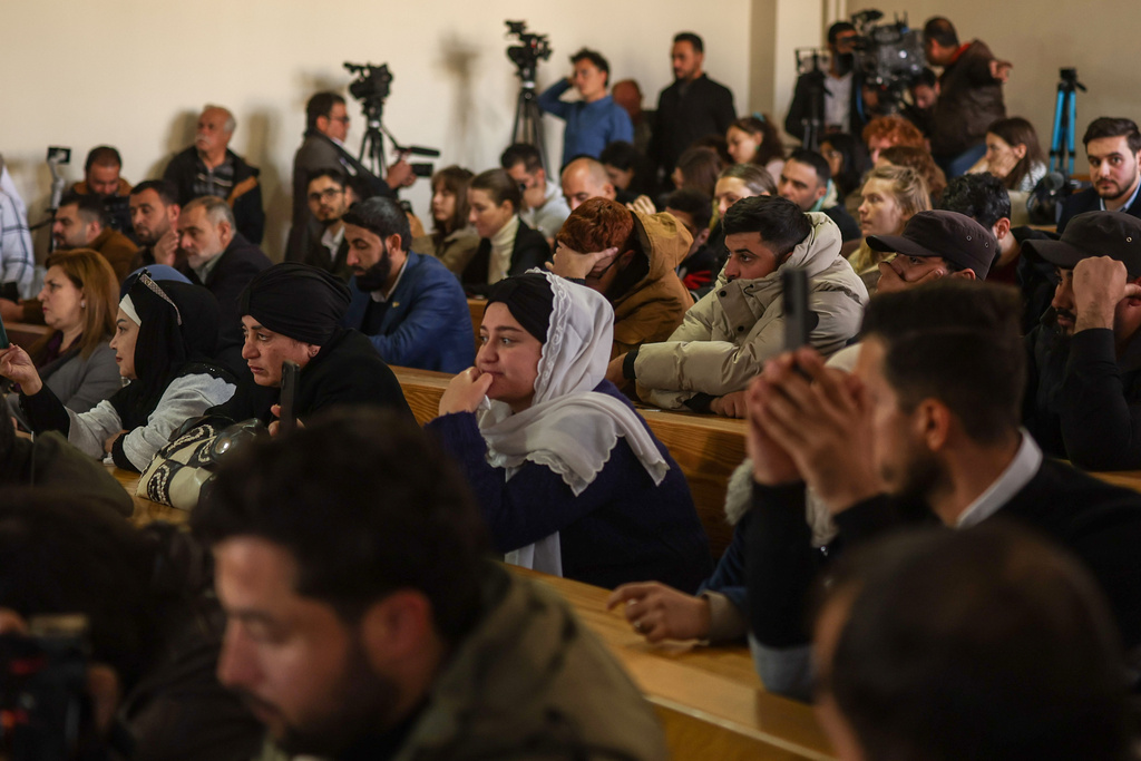 People attend Syria's first public trial related to deadly clashes in March along the country's coastal provinces, at the Palace of Justice in Aleppo, Syria, Tuesday, Nov. 18, 2025. (AP Photo/Ghaith Alsayed)