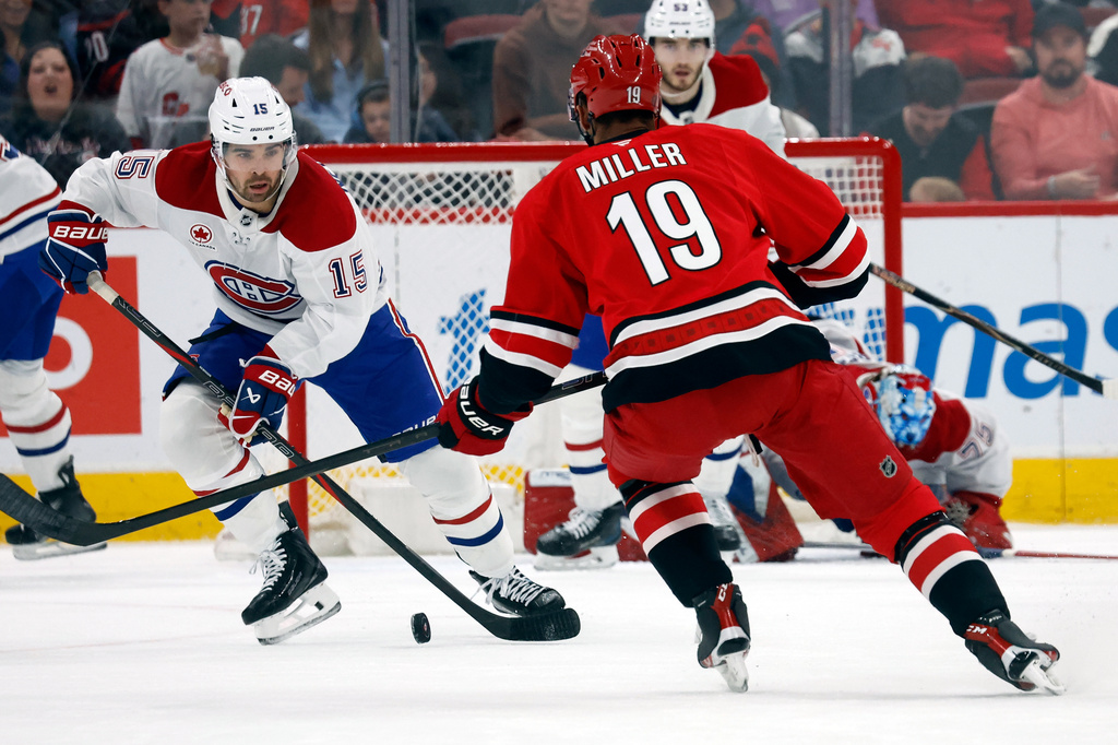 Montréal Canadiens' Alex Newhook (15) controls the puck in front of Carolina Hurricanes' K'andre Miller (19) during the first period of an NHL hockey game in Raleigh, N.C., Sunday, March 29, 2026. (AP Photo/Karl DeBlaker)