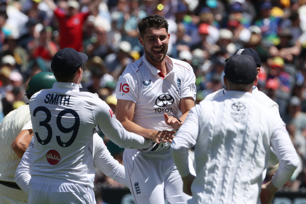England's Josh Tongue, center, celebrates with teammates after taking the wicket of Australia's Scott Boland during their Ashes cricket test match in Melbourne, Friday, Dec. 26, 2025. (AP Photo/Hamish Blair)