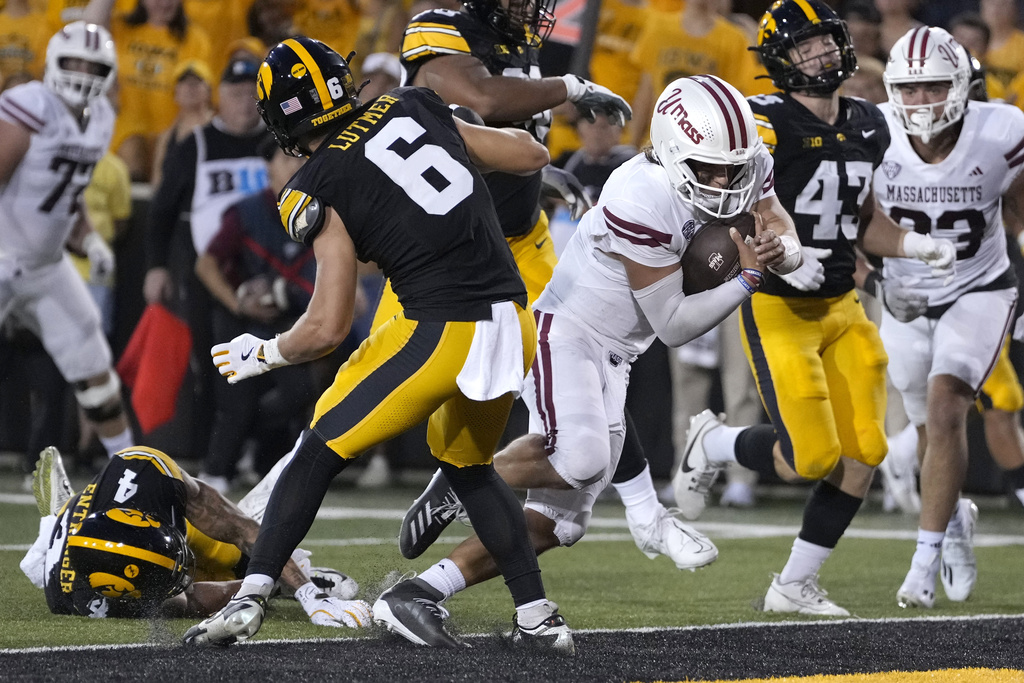 Massachusetts quarterback Grant Jordan, center right, runs past Iowa defensive back Zach Lutmer (6) for a touchdown in the first half of an NCAA college football game, Saturday, Sept. 13, 2025, in Iowa City, Iowa. (AP Photo/Charlie Neibergall)