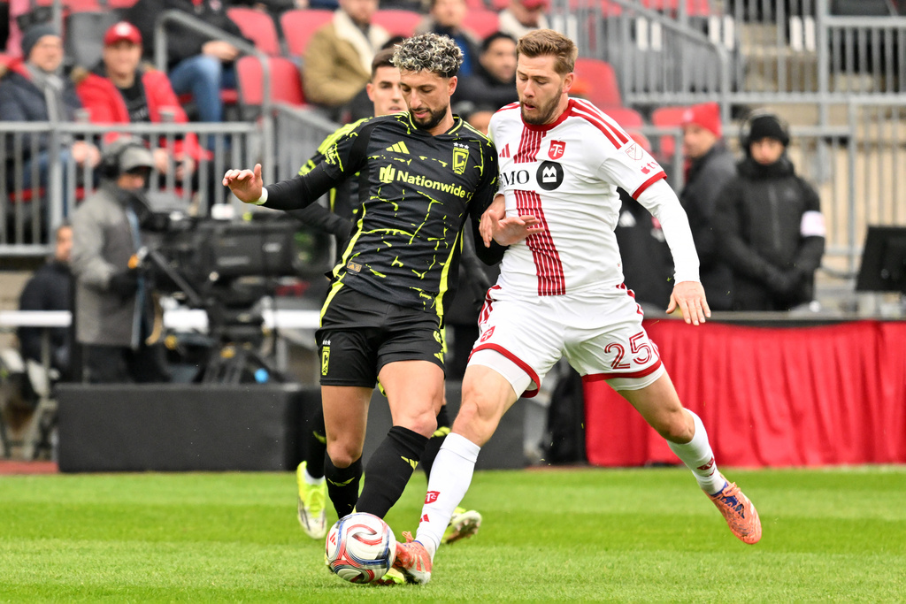 Columbus Crew forward Wessam Abou Ali, left, battles for the ball with Toronto FC defender Walker Zimmerman during the first half of an MLS soccer game in Toronto, Saturday, March 21, 2026. (Jon Blacker/The Canadian Press via AP)