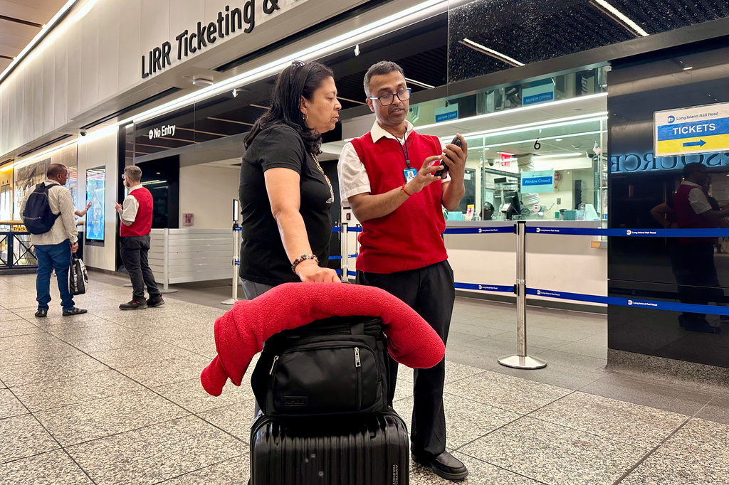 Long Island Rail Road employee Sujit Saha helps a passenger find her train at New York's Penn Station, Tuesday, May 19, 2026. (AP Photo/Richard Drew)