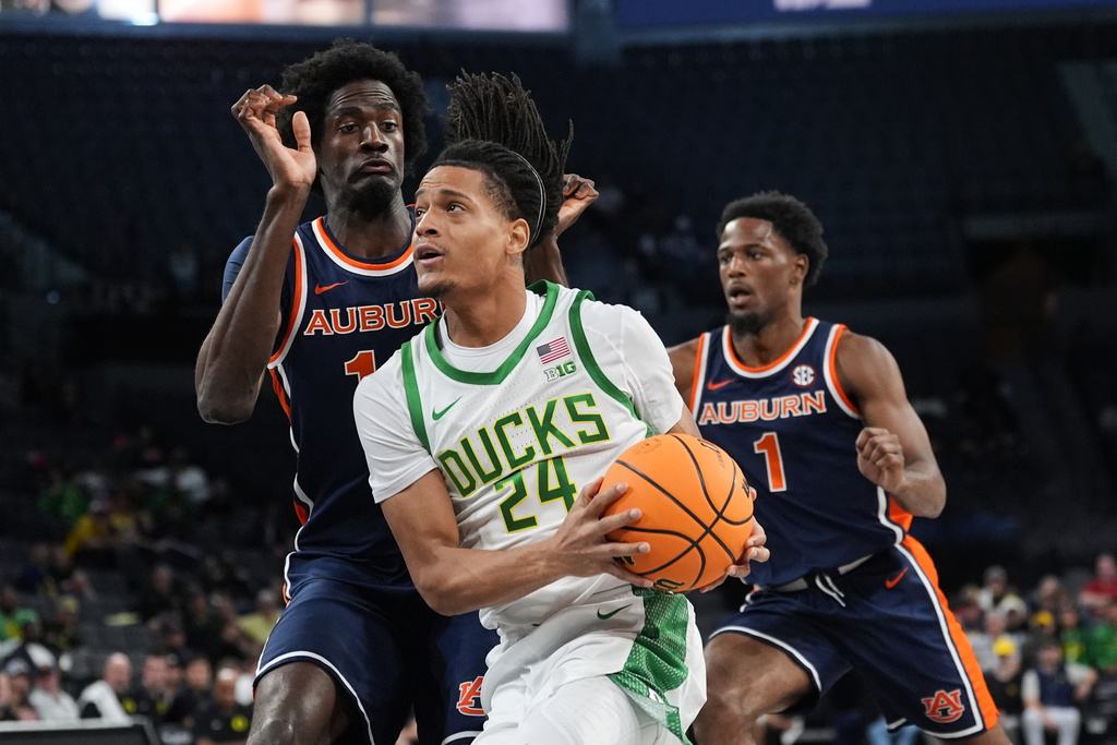 Oregon guard Jamari Phillips (24) drives against Auburn center Emeka Opurum (14) during the first half of an NCAA college basketball game in Las Vegas, Monday, Nov. 24, 2025. (AP Photo/Eric Gay)