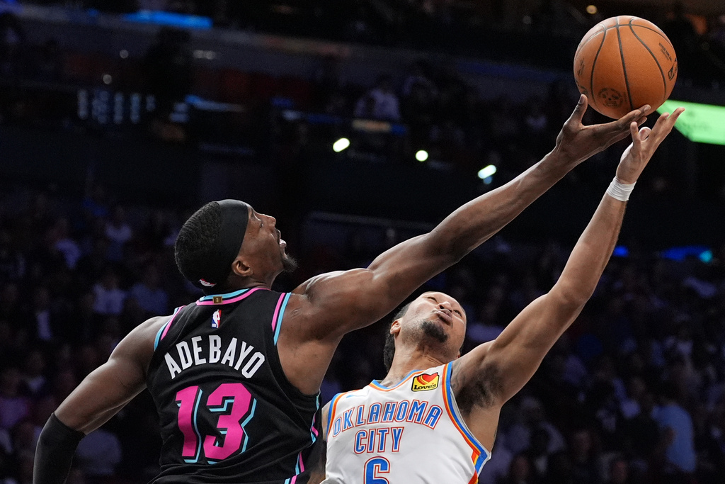 Miami Heat center Bam Adebayo (13) and Oklahoma City Thunder forward Jaylin Williams (6) battle for a rebound during the first half of an NBA basketball game, Saturday, Jan. 17, 2026, in Miami. (AP Photo/Rebecca Blackwell)
