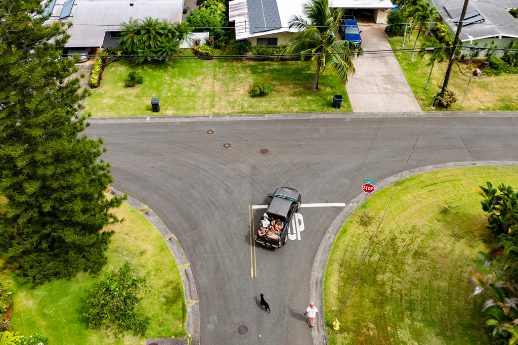 An aerial view shows Kimeona Kane sitting with his nephew, Gabriel Shimaoka, and niece, Genesis Shimaoka, in the bed of his pickup truck, Friday, July 17, 2026, in Kailua, Hawaii. (AP Photo/Mengshin Lin)
