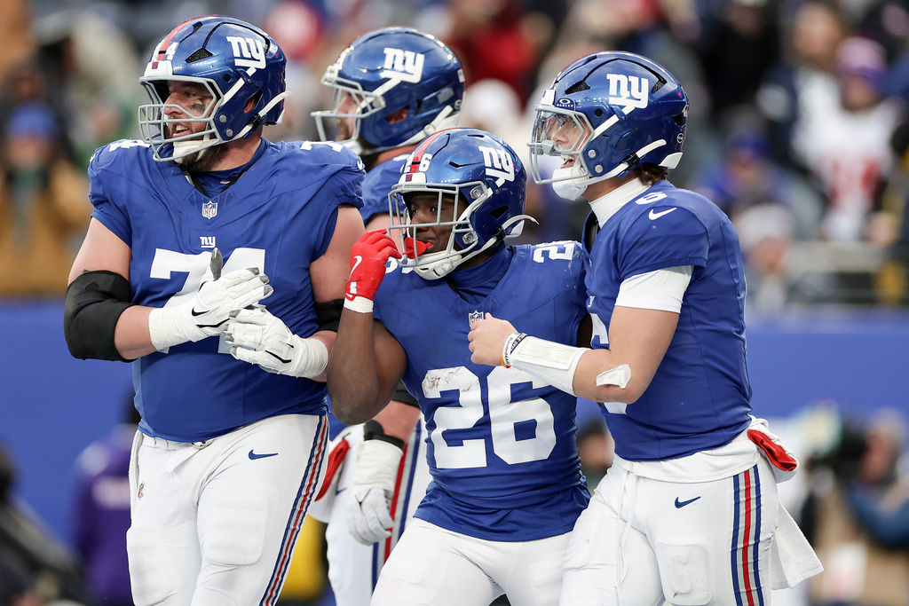 New York Giants running back Devin Singletary (26) celebrates with quarterback Jaxson Dart (6) and guard Greg van Roten (74) after scoring a touchdown against the Dallas Cowboys during the fourth quarter of an NFL football game, Sunday, Jan. 4, 2026, in East Rutherford, N.J. (AP Photo/Adam Hunger)