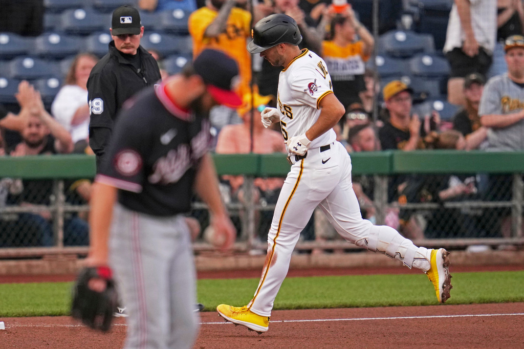 Pittsburgh Pirates' Brandon Lowe, right, rounds third after hitting a solo home run off Washington Nationals pitcher PJ Poulin, left, during the first inning of a baseball game in Pittsburgh, Tuesday, April 14, 2026. (AP Photo/Gene J. Puskar)