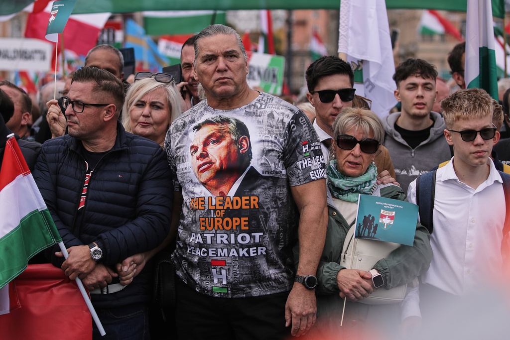 A man wearing a T-shirt with Hungarian Prime Minister Viktor Orban attends a pro-government march marking the 69th anniversary of the outbreak of Hungary's 1956 revolution against communist rule and the Soviet Union, in Budapest, Hungary, Thursday, Oct. 23, 2025. (AP Photo/Rudolf Karancsi)