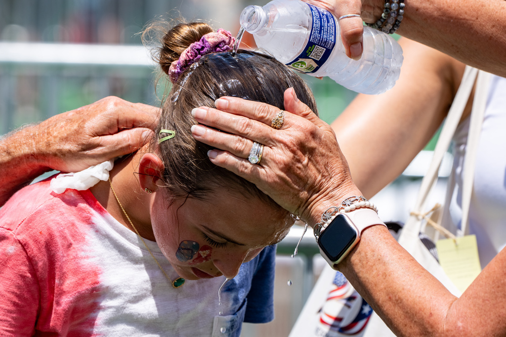 FILE - Ruth, 11, from Burke, Va., gets cold water poured on her head to cool off at the Great American State Fair on the National Mall, July 2, 2026, in Washington. (AP Photo/Alex Brandon, File)