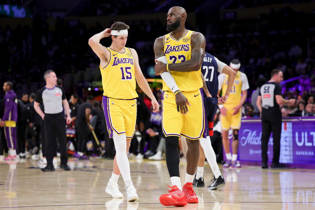 Los Angeles Lakers forward LeBron James, right, and guard Austin Reaves stand during a timeout during the first half of an NBA basketball game against the Washington Wizards Monday, March 30, 2026, in Los Angeles. (AP Photo/Ryan Sun)