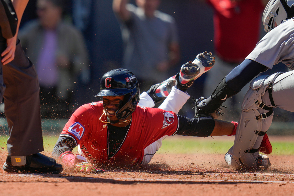 Cleveland Guardians' Angel Martínez scores on a single hit by Gabriel Arias as Detroit Tigers catcher Dillon Dingler, right, reaches with the tag during the fourth inning of Game 1 of the American League Wild Card baseball playoff series in Cleveland, Tuesday, Sept. 30, 2025. (AP Photo/Sue Ogrocki)
