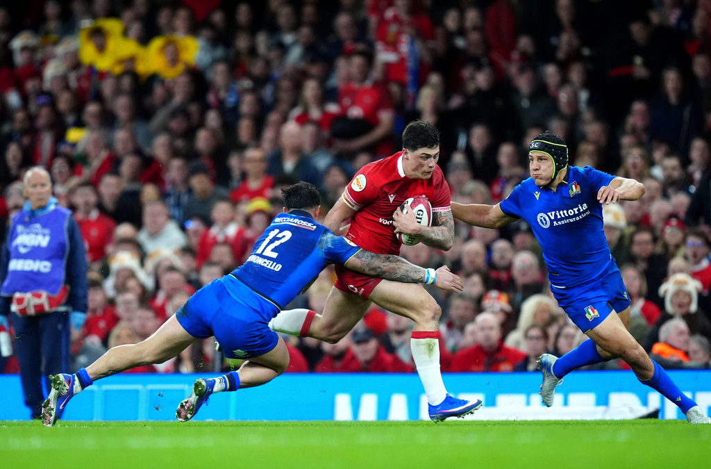 Wales' Louis Rees-Zammit is tackled by Italy's Tommaso Menoncello during the Men's Six Nations match between Wales and Italy in Cardiff, Wales, Saturday March 14, 2026. (David Davies/PA via AP)