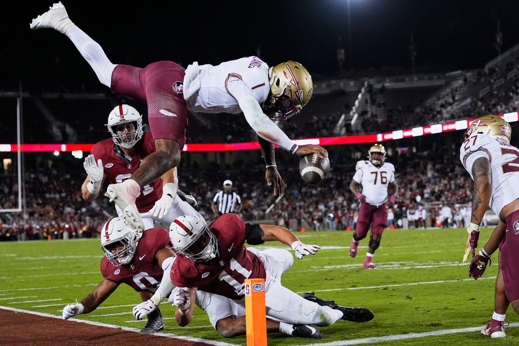 Florida State quarterback Tommy Castellanos (1) leaps into the end zone for a touchdown against Stanford linebacker Tevarua Tafiti (11) during the first half of an NCAA college football game, Saturday, Oct. 18, 2025, in Stanford, Calif. (AP Photo/Godofredo A. Vásquez)