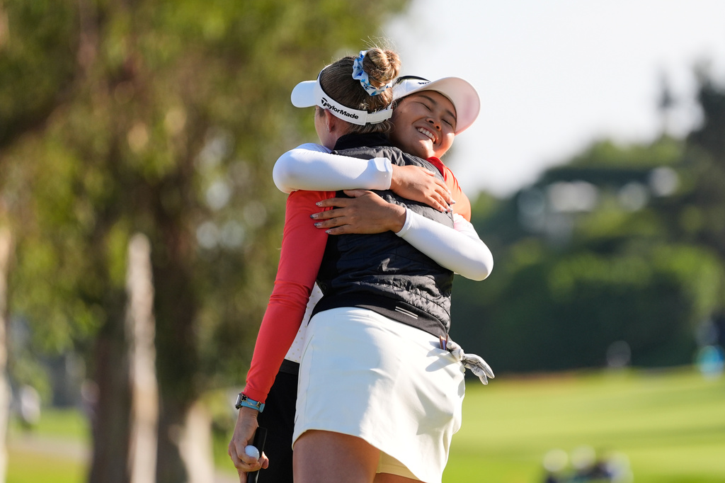 Sora Kamiya, of Japan, facing, hugs Nelly Korda after finishing the day on the 18th green during the third round of the U.S. Women's Open golf tournament Saturday, June 6, 2026, in the Pacific Palisades area of Los Angeles. (AP Photo/Ashley Landis)