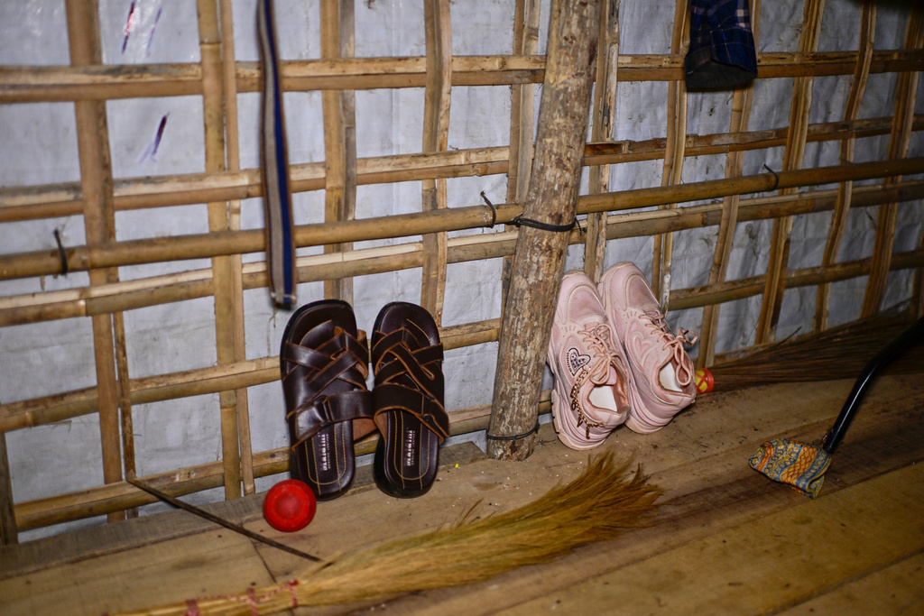 Brown sandals of 13-year-old Mohammed are propped against the wall, alongside sparkly pink sneakers belonging to his sister, inside their shelter in the Rohingya refugee camp in Cox's Bazar, Bangladesh, Saturday, Nov. 22, 2025. (AP Photo/Mahmud Hossain Opu)