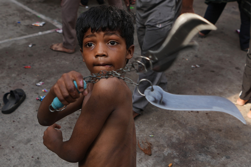 A Shiite Muslim child flagellates himself during a Muharram procession in Ahmedabad, India, Tuesday, June 23, 2026. (AP Photo/Ajit Solanki)