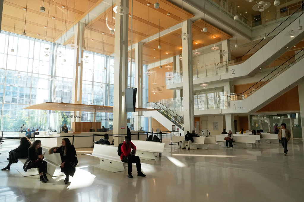 People wait inside the Paris courthouse, in Paris, France, Monday, April 20, 2026. (AP Photo/Michel Euler)