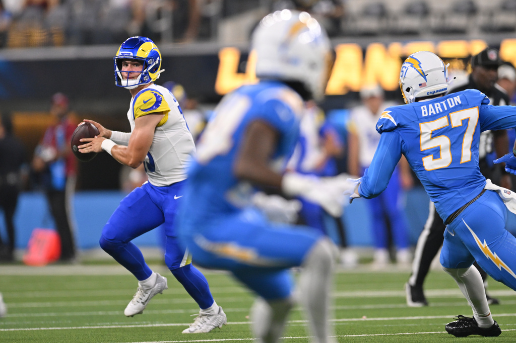 Los Angeles Rams quarterback Ty Simpson, left, scrambles during the first half of an NFL preseason football game against the Los Angeles Chargers Thursday, Aug. 27, 2026, in Inglewood, Calif. (AP Photo/Katie Chin)