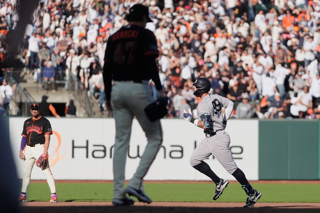 San Francisco Giants pitcher Ryan Borucki, foreground, reacts after allowing a home run to New York Yankees' Aaron Judge, right, during the fifth inning of a baseball game in San Francisco, Saturday, March 28, 2026. (AP Photo/Jeff Chiu)