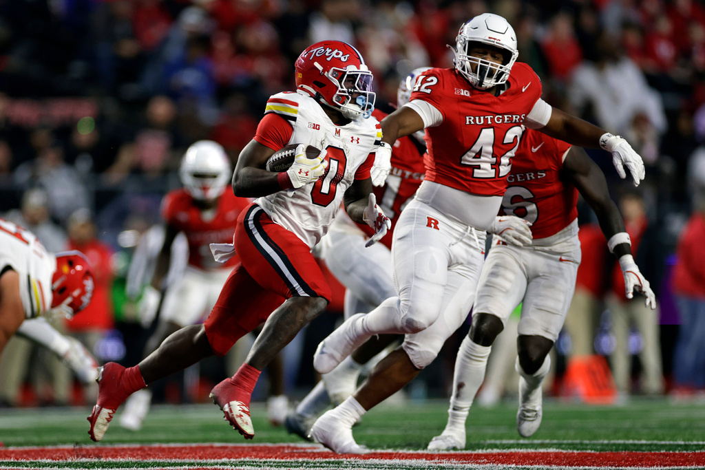 Maryland running back Dejuan Williams (0) rucarriesh the ball past Rutgers defensive lineman DJ Allen (42) during the second half of an NCAA college football game Saturday, Nov. 8, 2025, in Piscataway, N.J. (AP Photo/Adam Hunger)