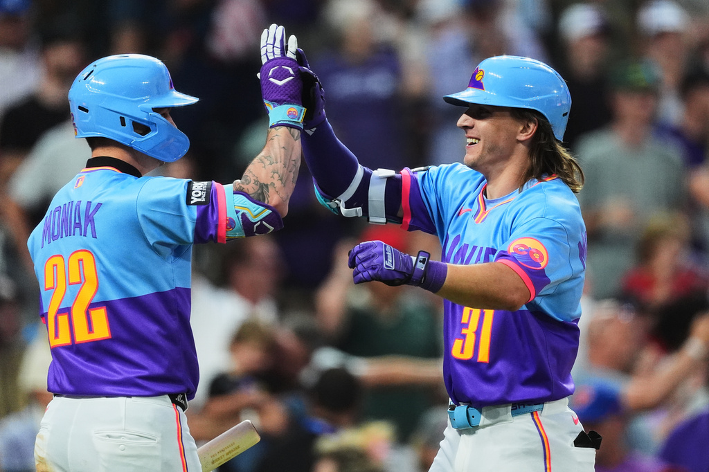 Colorado Rockies' Mickey Moniak, left, congratulates Jake McCarthy who returns to the dugout after hitting a grand slam off San Francisco Giants relief pitcher Matt Gage in the fifth inning of a baseball game Friday, July 3, 2026, in Denver. (AP Photo/David Zalubowski)