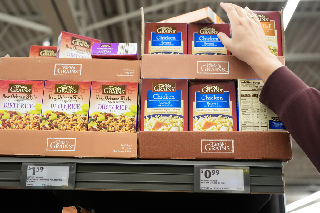 Kyndall Keeland reaches for a box of rice while shopping for supplies to make 700 Thanksgiving meals for community members Tuesday, Nov. 25, 2025, in Nixa, Mo. (AP Photo/Jeff Roberson)