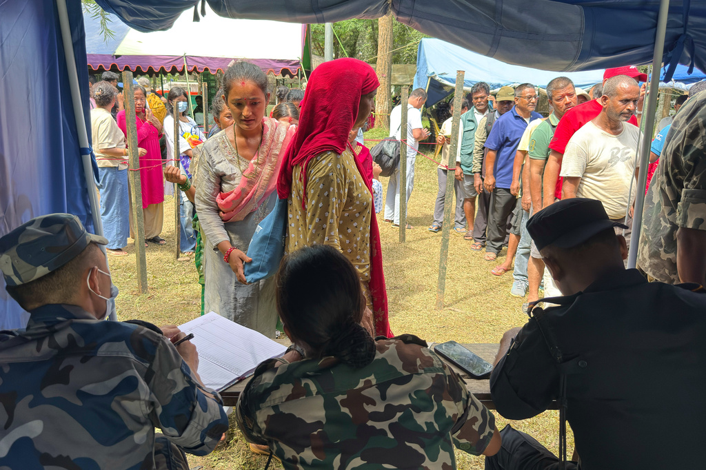 People rescued from an area cut off by flash flooding line up to register at an army camp in Nepal's Nuwakot district, Friday, Aug. 28, 2026. (AP Photo/Rajesh Kumar Singh)