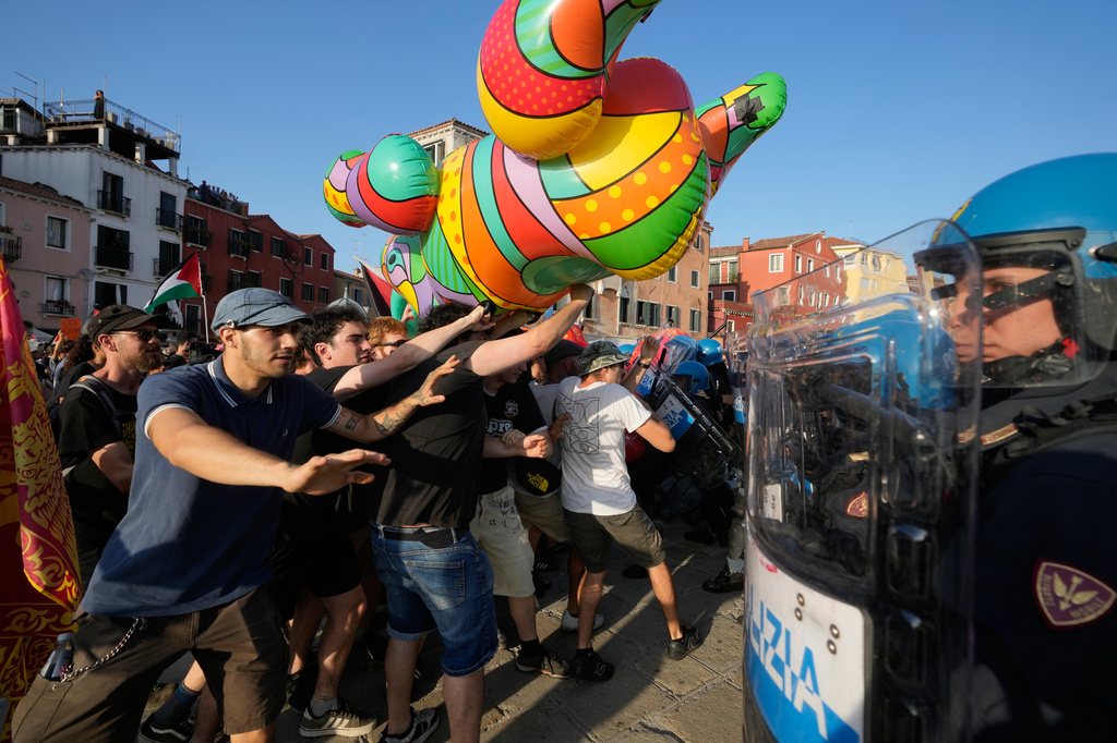 Police officers face demonstrators gathered to protest against U.S. Ambassador Tilman Fertitta's luxury yacht 'Boardwalk" presence in Venice, Friday, July 17, 2026. (AP Photo/Luca Bruno) CORRECTS NAME OF YACHT TO BOARDWALK INSTEAD OF BOARDWALL"