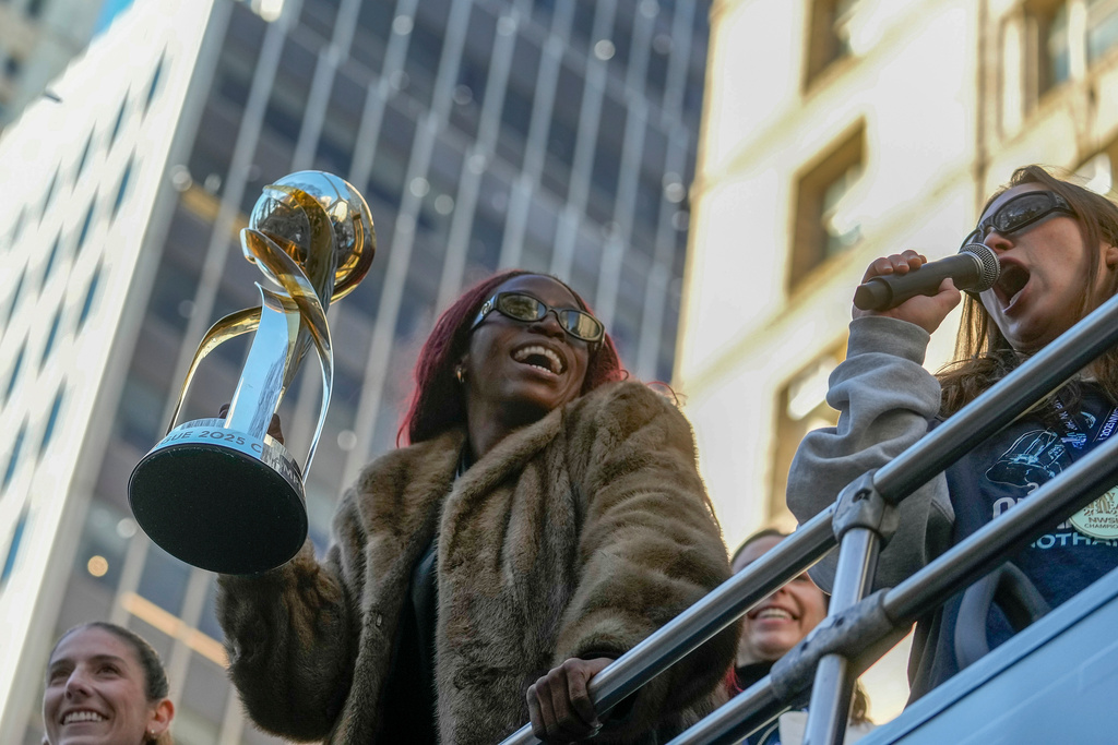 Gotham Football Club captain Mandy Freeman holds up the NWSL championship trophy as she rides down Broadway with the team during a parade celebrating their win over the Washington Spirit, Monday, Nov. 24, 2025, in New York. (Michael Appleton/New York City Mayor's Office via AP)
