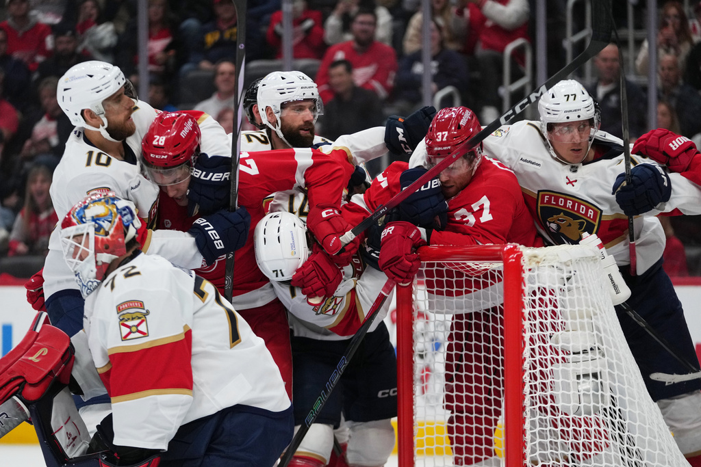 Detroit Red Wings and Florida Panthers players clutch and grab each other in the second period of an NHL hockey game Wednesday, Oct. 15, 2025, in Detroit. (AP Photo/Paul Sancya)