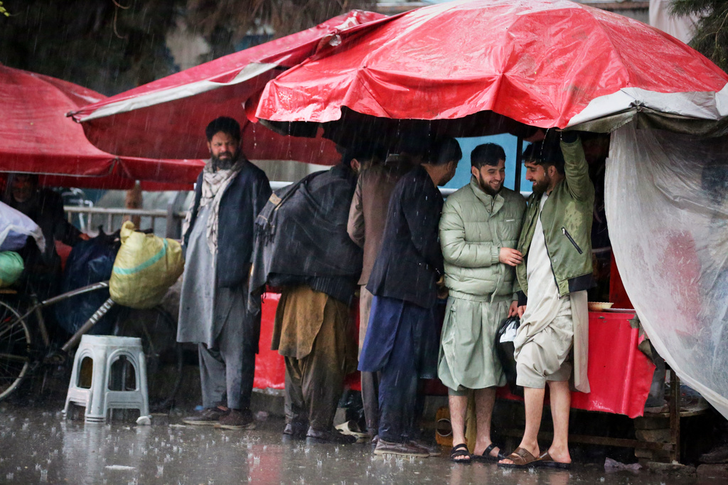 Residents take cover from heavy rain at a market in Kabul, Afghanistan, Tuesday, March 31, 2026. (AP Photo/Siddiqullah Alizai)