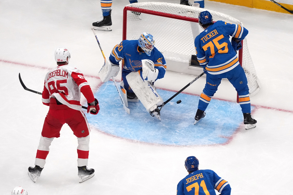 Detroit Red Wings' Elmer Soderblom (85) scores past St. Louis Blues goaltender Jordan Binnington (50) and Tyler Tucker (75) during the second period of an NHL hockey game Tuesday, Oct. 28, 2025, in St. Louis. (AP Photo/Jeff Roberson)