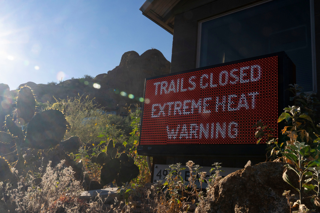 A sign warns hikers of trail closures due to extreme heat at Camelback Mountain on Thursday, March 19, 2026, in Phoenix. (AP Photo/Rebecca Noble)
