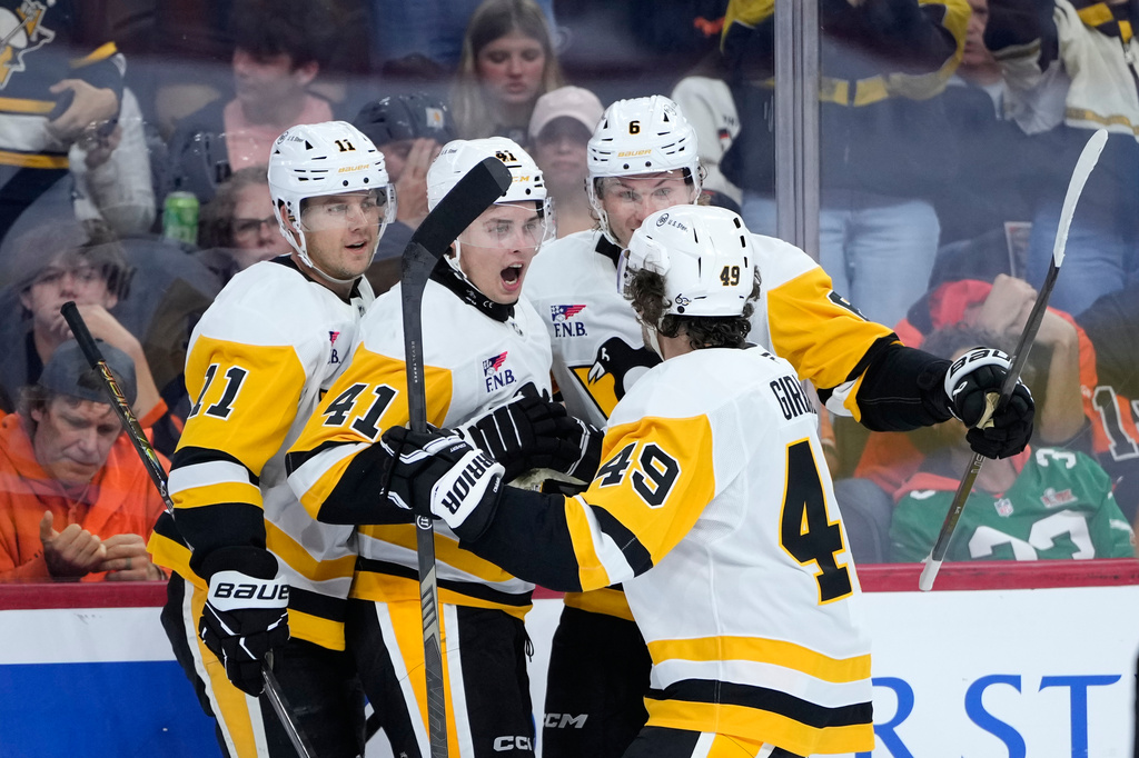 Pittsburgh Penguins' Filip Hallander (11), Ville Koivunen (41), Kaedan Korczak (6) and Samuel Girard (49) celebrate after a goal by Koivunen during the first period of an NHL hockey game against the Philadelphia Flyers Wednesday, Sept. 30, 2026, in Philadelphia. (AP Photo/Matt Slocum)