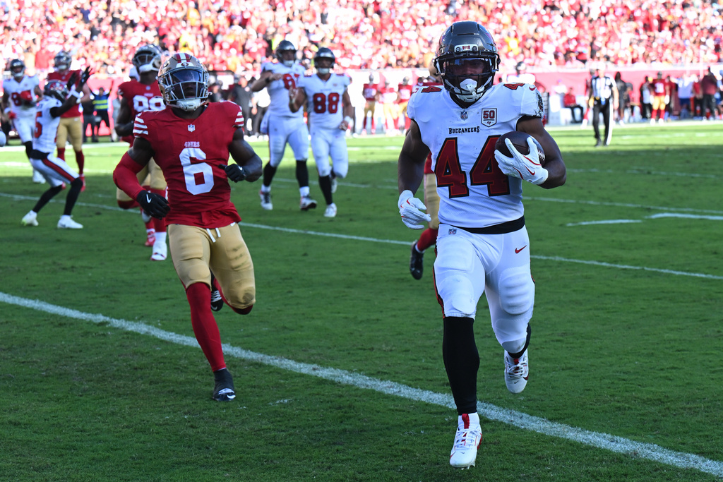 Tampa Bay Buccaneers running back Sean Tucker (44) runs for a touchdown past San Francisco 49ers safety Malik Mustapha (6) during the first half of an NFL football game in Tampa, Fla., Sunday, Oct. 12, 2025. (AP Photo/Jason Behnken)