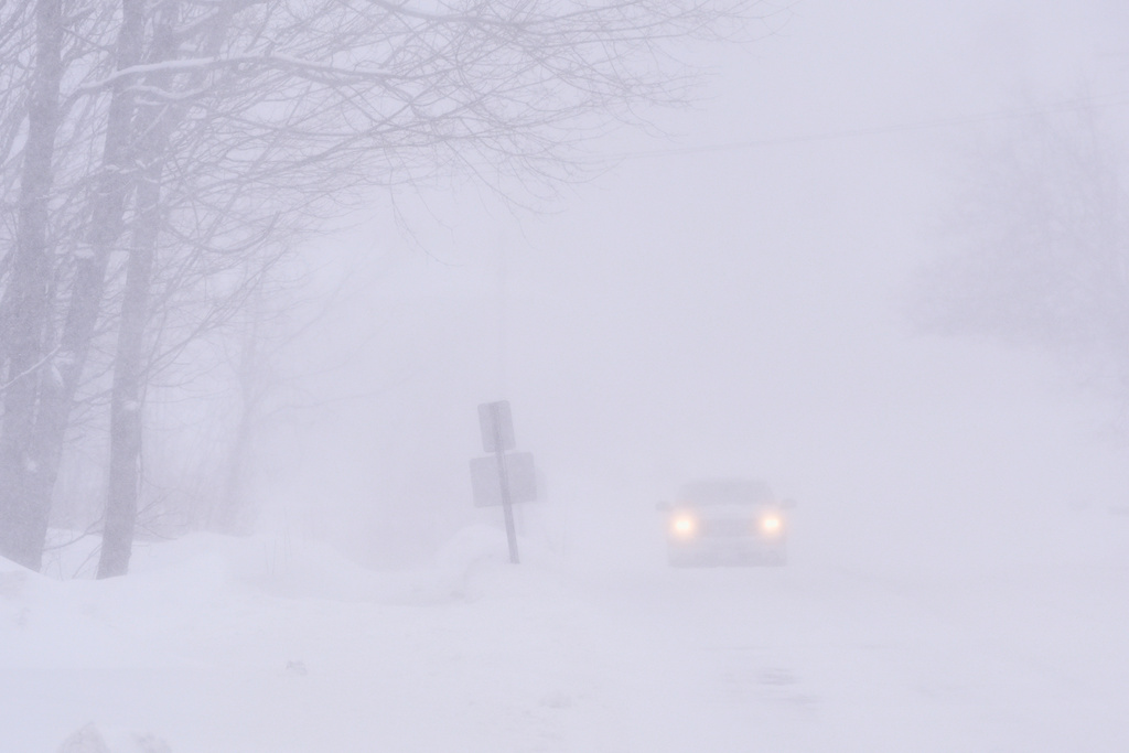 A pick-up truck drives in nearly white-out conditions during a winter storm, Monday, Feb. 23, 2026, in Derry, N.H. (AP Photo/Charles Krupa)
