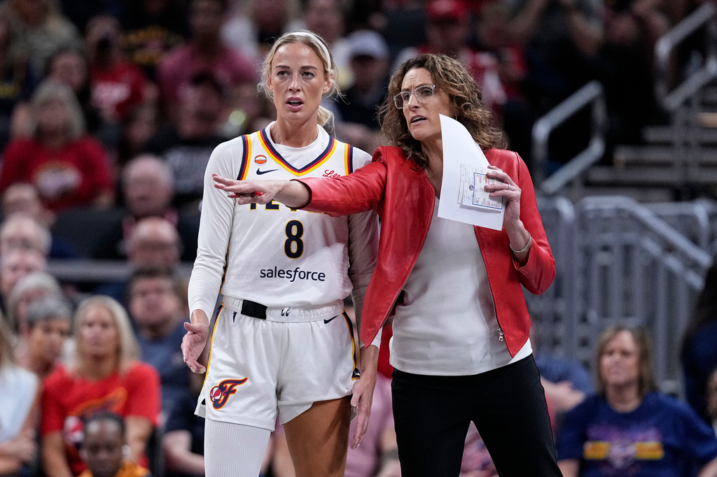 Indiana Fever head coach Stephanie White talks with guard Sophie Cunningham (8) as the Fever played the New York Liberty in the first half of a WNBA basketball game in Indianapolis, Tuesday, Aug. 11, 2026. (AP Photo/Michael Conroy)