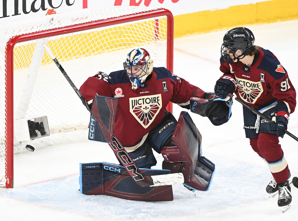 Montreal Victoire goaltender Ann-Renee Desbiens (35) looks back on her net after being scored on by Minnesota Frost's Jincy Roese, not shown, as Victoire's Maggie Flaherty (91) looks on during the overtime period of a PWHL playoff hockey game in Laval, Quebec, Saturday, May 2, 2026. (Graham Hughes/The Canadian Press via AP)