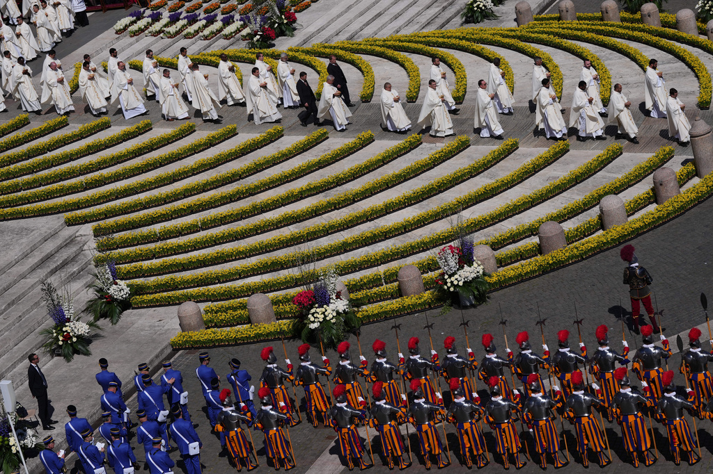 Priests reach toward the faithful to distribute Holy Communion as Pope Leo XIV presides over Easter Mass in St. Peter's Square at the Vatican, Sunday, April 5, 2026.(AP Photo/Alessandra Tarantino)