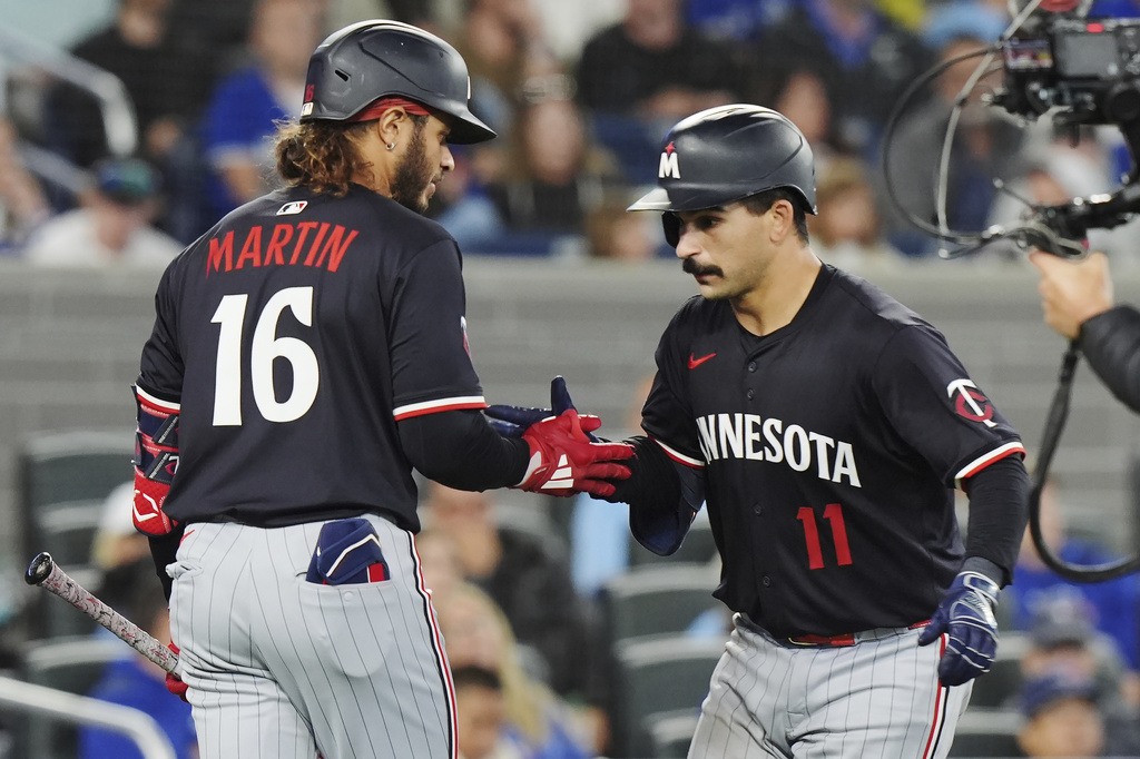 Minnesota Twins' Mickey Gasper, right, celebrates his solo home run against the Toronto Blue Jays with Austin Martin (16) during the ninth inning of a baseball game in Toronto on Tuesday, Aug. 26, 2025. (Frank Gunn/The Canadian Press via AP)