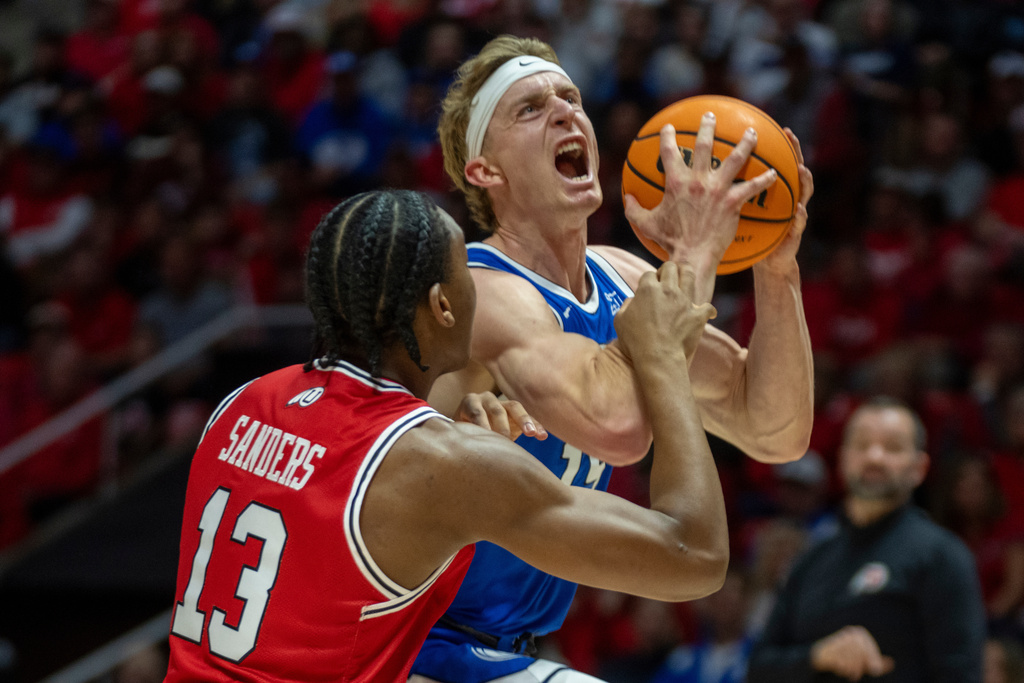 BYU guard Richie Saunders, right, goes to the hoop as Utah forward Kendyl Sanders (13) defends during the first half of an NCAA college basketball game Saturday, Jan. 10, 2026, in Salt Lake City. (AP Photo/Rick Egan)