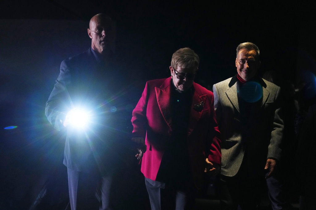 Elton John, center, and David Furnish, right, arrive at the Valentino Spring/Summer 2026 Haute Couture collection presented in Paris, Wednesday, Jan. 28, 2026. (AP Photo/Aurelien Morissard)