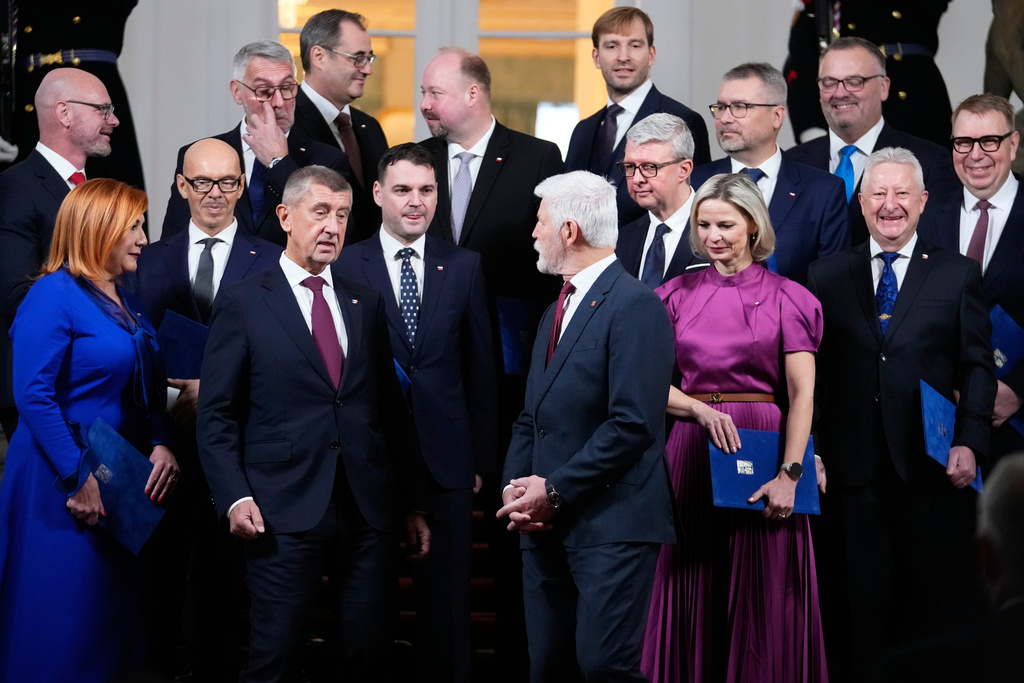 Czech Republic's President Petr Pavel, center, and Prime Minister Andrej Babis, center left, pose for a family photo with newly appointed government members at the Prague Castle in Prague, Czech Republic, Monday, Dec. 15, 2025. (AP Photo/Petr David Josek)