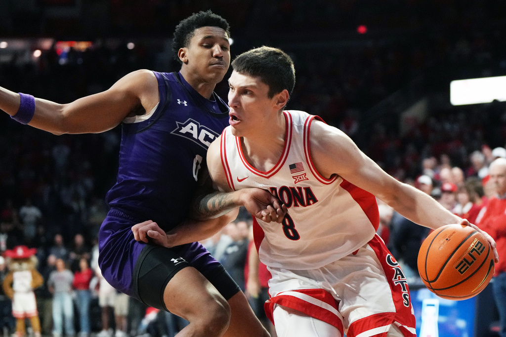 Arizona forward Ivan Kharchenkov (8) drives on Abilene Christian guard Zy Wright during the first half of an NCAA college basketball game, Tuesday, Dec. 16, 2025, in Tucson, Ariz. (AP Photo/Rick Scuteri)