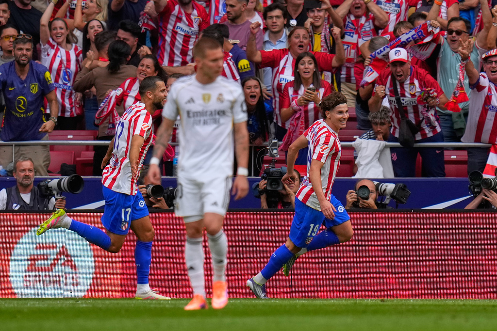 Atletico Madrid's Julian Alvarez, right, celebrates after scoring his side's fourth goal during the Spanish La Liga soccer match between Atletico Madrid and Real Madrid at Metropolitano stadium, in Madrid, Spain, Saturday, Sept. 27, 2025. (AP Photo/Manu Fernandez)
