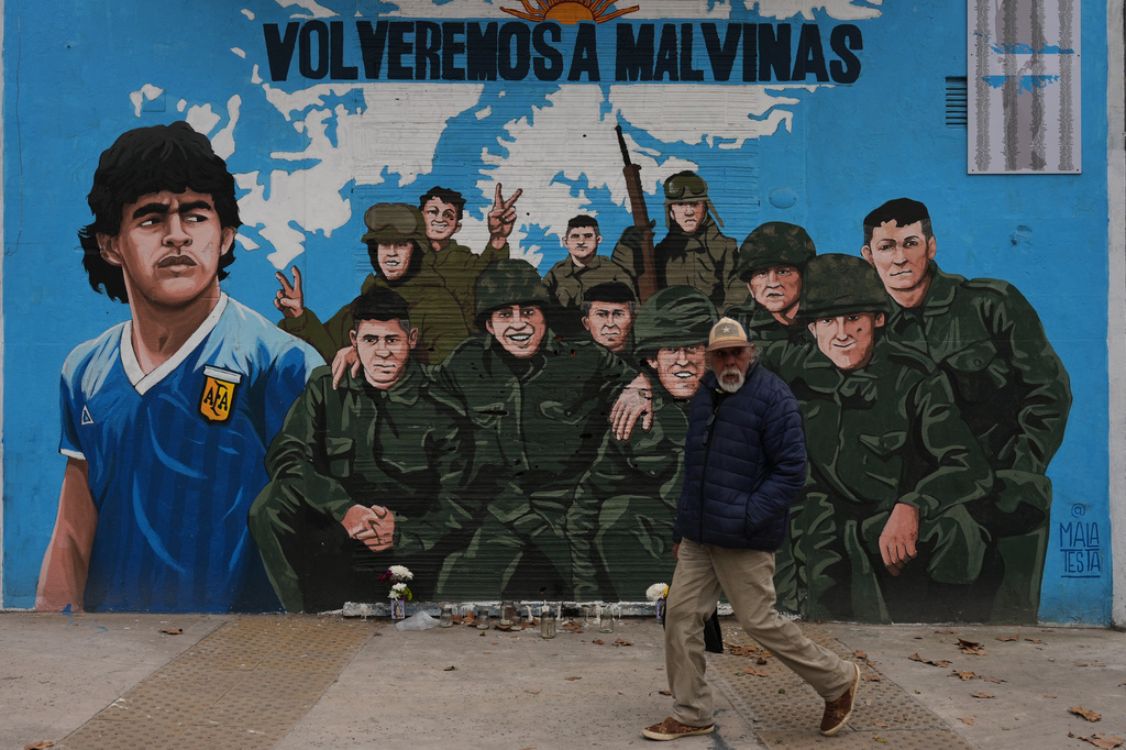 A man walks past a street mural depicting late soccer star Diego Maradona and veterans of the 1982 war between Argentina and Britain over the Falkland Islands, known in Argentina as the Malvinas, in Buenos Aires, Argentina, Wednesday, July 15, 2026. (AP Photo/Rodrigo Abd)