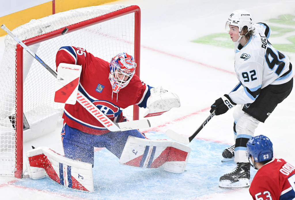 Utah Mammoth's Logan Cooley (92) moves in on Montreal Canadiens goaltender Sam Montembeault during second period NHL hockey action in Montreal, Saturday, Nov. 8, 2025. (Graham Hughes/The Canadian Press via AP)